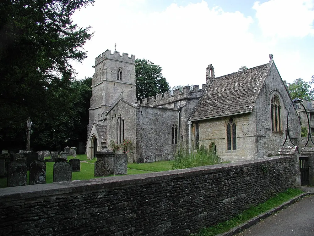 The stone tower of the Church of the Holy Rood among trees at Ampney Crucis near Cirencester