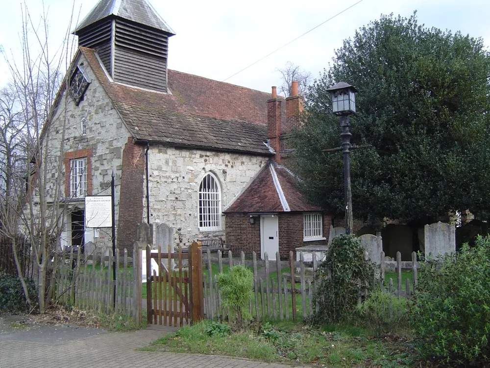 The tower of St George's Church among trees in the centre of Esher